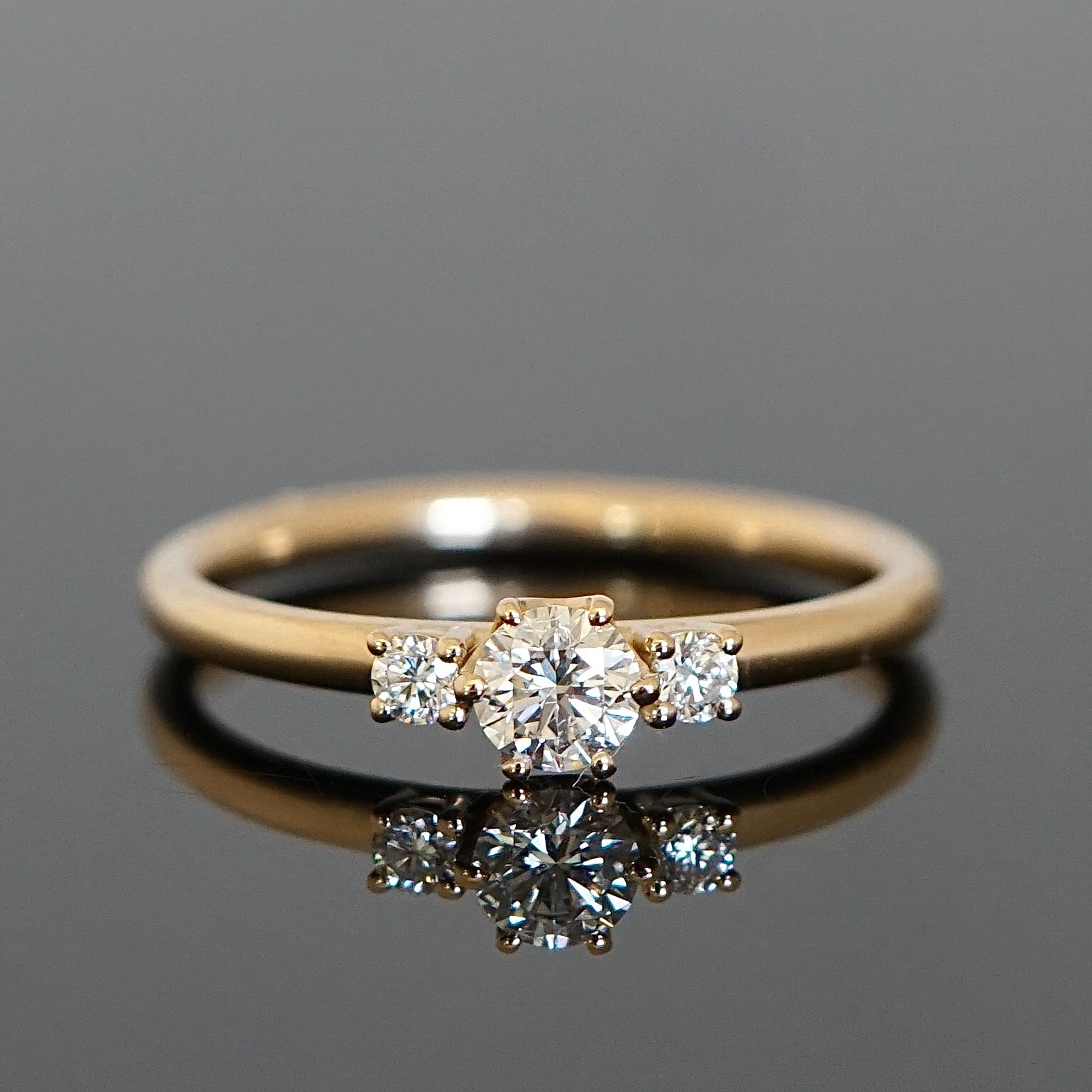 Verlobungsring Mittelstein 0,25 Ct., umgeben von 2 kleineren Diamanten
