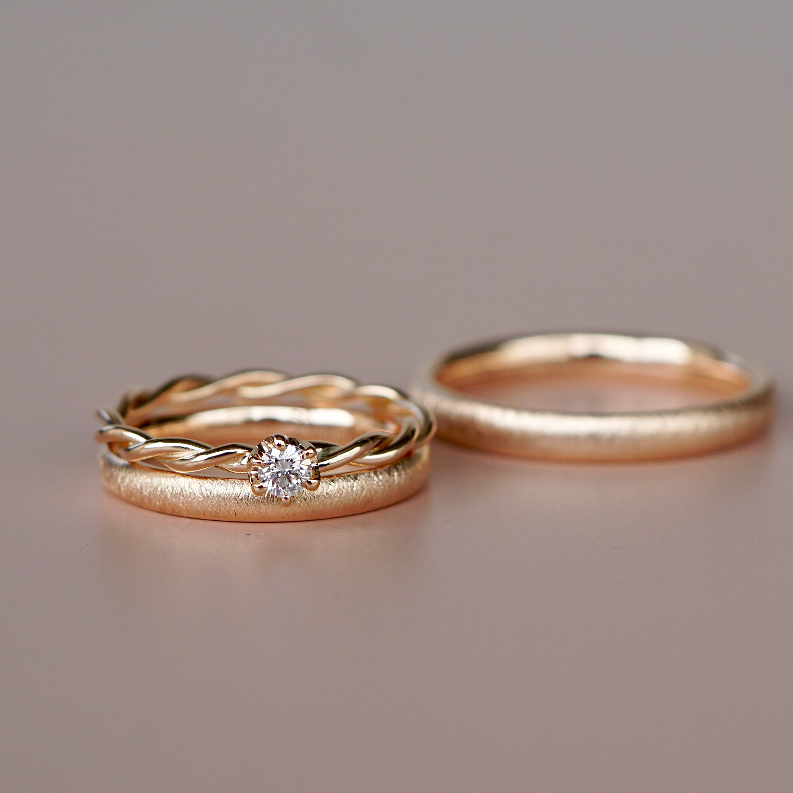 Eheringe aus Roségold in Kombination mit dem Verlobungsring. Kordelring mit Diamanten. Trauring Kombination.