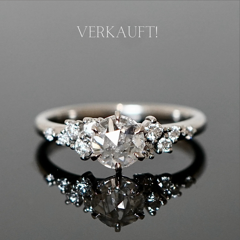 Romantischer Diamantring mit vielen kleinen Diamanten seitlich auf der Ringschiene.