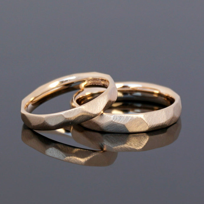 Außergewöhnliche Eheringe mit Facetten aus Roségold. Handwerkliche Eheringe, Hammerschlag.