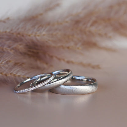 Eheringe mit samtiger Oberfläche und Diamantring aus Platin.