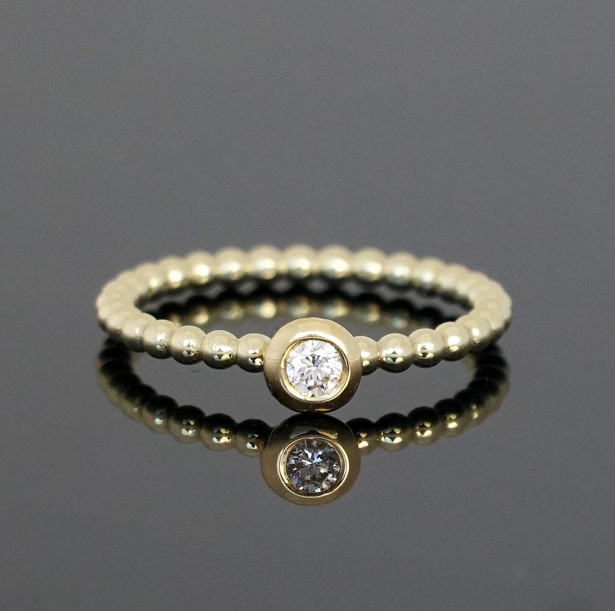 Vorsteckring mit zarten Kugeln und runder Fassung mit Diamant 