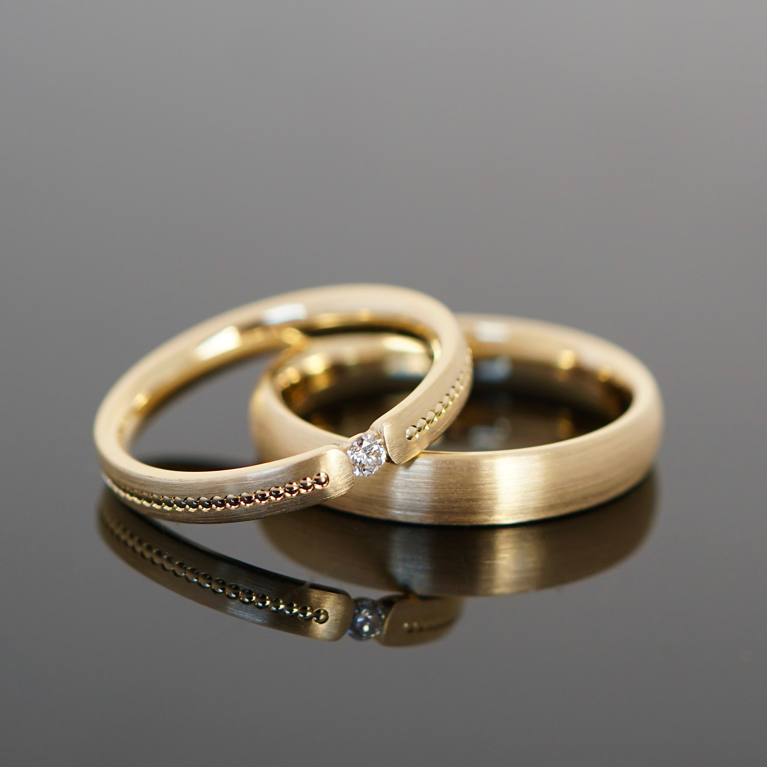 Vintage Trauringe ganz nach deinen Wünschen. Retro Trauringe aus Gold mit Perlierung und Diamant. Spannring Damenring 